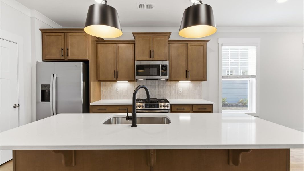 Notable kitchen space with elegant pendant lighting and a large island perfect for entertaining