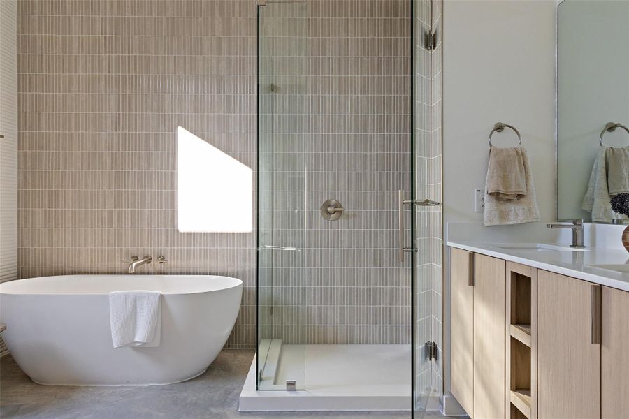 Bathroom with tile walls, vanity, and plus walk in shower