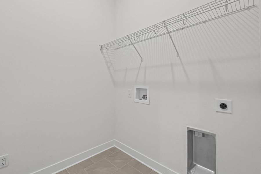 Laundry area featuring electric dryer hookup, washer hookup, and light tile patterned flooring