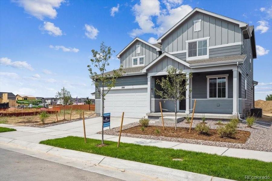 Front exterior of a new home in Farmlore, Brighton, CO, highlighting curb appeal (Image 1).