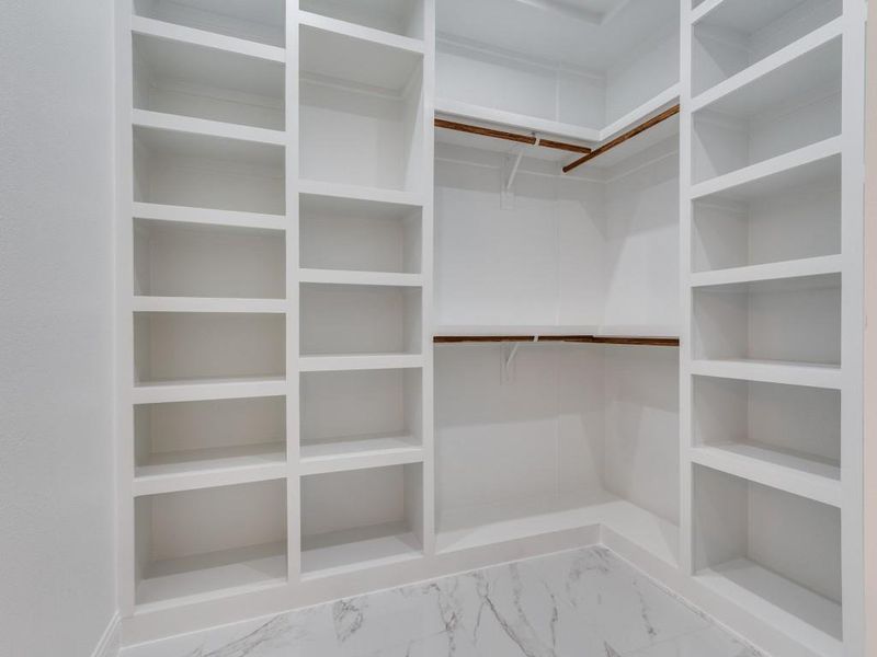 Spacious closet with light marble finish floors.