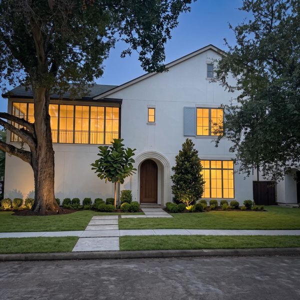 Every window glows gold under the oaks, and the corner lot gives it room to breathe in a neighborhood where that's rare. Every window glows gold under the oaks, and the corner lot gives it room to breathe in a neighborhood where that's rare.