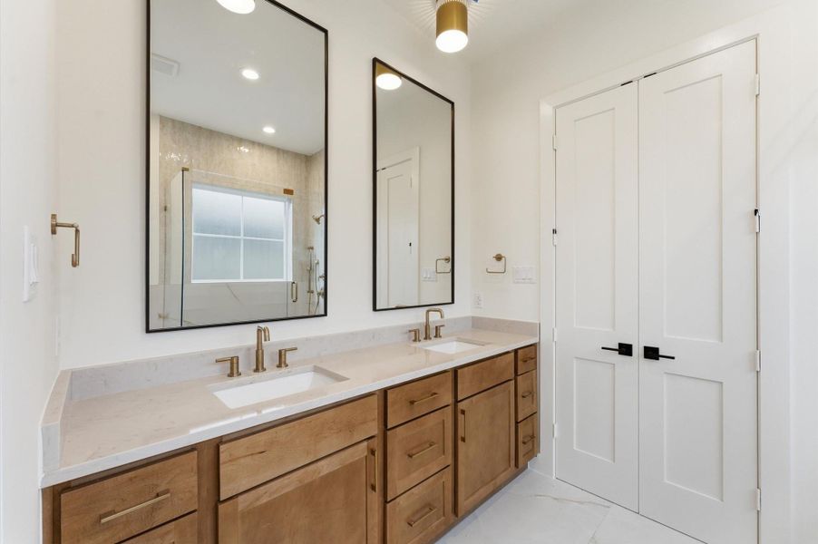 Dual-sink vanity and quartz countertops enhance the primary bathroom.