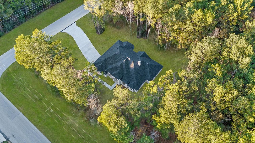 This aerial view showcases a secluded home surrounded by lush trees, offering privacy and a serene natural setting. The house features a winding driveway, nestled within a spacious, wooded lot. This aerial view showcases a secluded home surrounded by lush trees, offering privacy and a serene natural setting. The house features a winding driveway, nestled within a spacious, wooded lot.