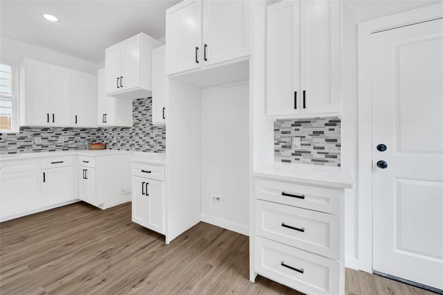 Sleek backsplash, black hardware, and generous storage space. Sleek backsplash, black hardware, and generous storage space.