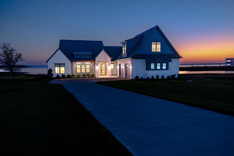 Modern farmhouse style home featuring driveway, a front yard, and a garage Modern farmhouse style home featuring driveway, a front yard, and a garage