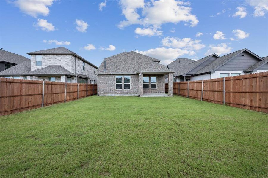 Rear view of house with a patio area, brick siding, a fenced backyard, and a shingled roof