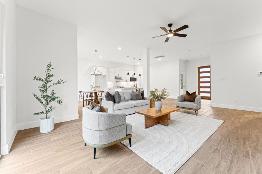 Spacious open-concept living area filled with natural light, showcasing beautiful flooring, recessed lighting, and seamless flow to the dining and kitchen areas. Spacious open-concept living area filled with natural light, showcasing beautiful flooring, recessed lighting, and seamless flow to the dining and kitchen areas.