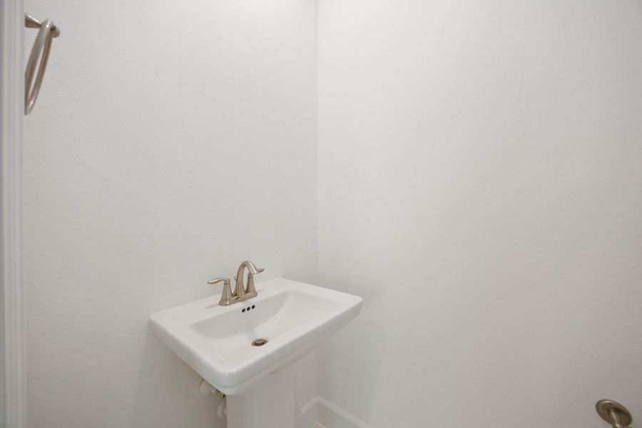 A perfect pop-in powder room—sleek, simple, and tucked just off the main living space. (Note: Mirror will be installed prior to closing.)