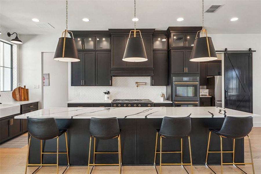 Large kitchen island and custom lighting throughout