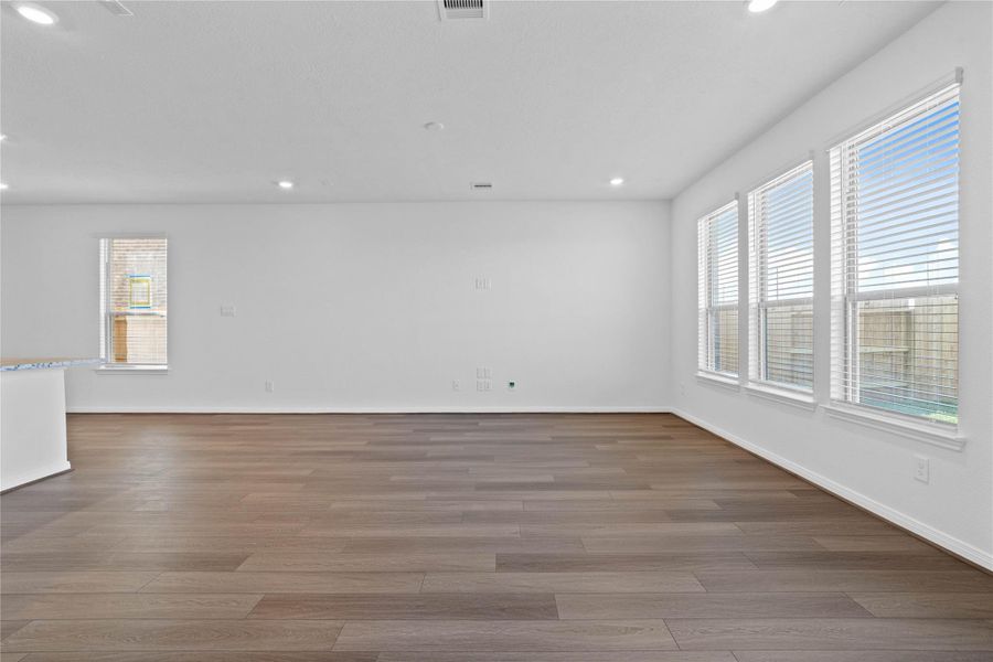 This bright and airy Great Room offers a spacious layout ideal for both relaxing evenings and lively gatherings. Designed for comfort and connection, it features flooring, large windows with blinds, high ceilings, recessed lighting, and seamless access to the stunning kitchen and dining—perfect for everyday living and entertaining alike.