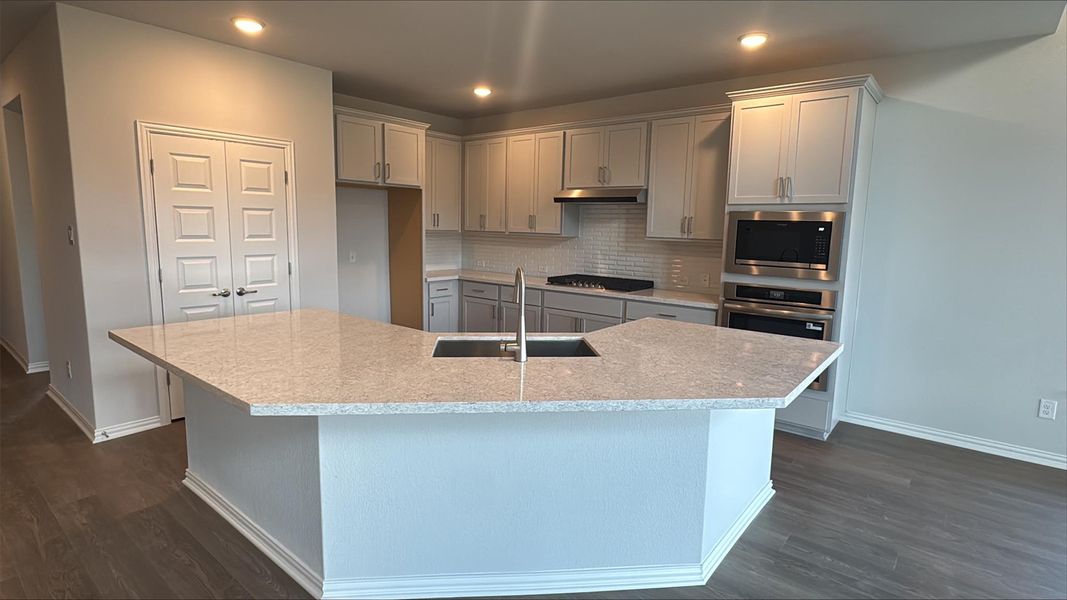 Kitchen featuring decorative backsplash, appliances with stainless steel finishes, gray cabinetry, dark wood-style flooring, and recessed lighting Kitchen featuring decorative backsplash, appliances with stainless steel finishes, gray cabinetry, dark wood-style flooring, and recessed lighting