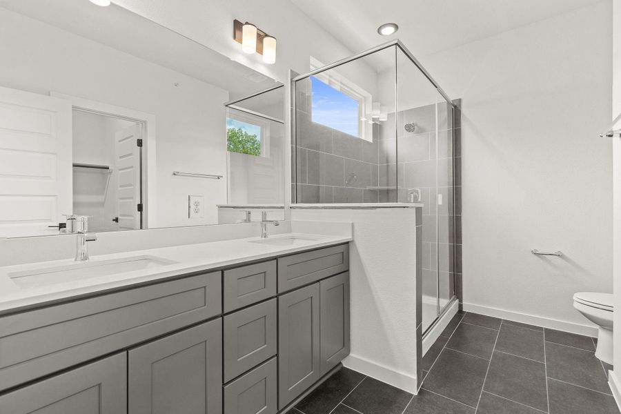 Double vanity and a spacious glass-enclosed shower create a modern bathroom retreat.