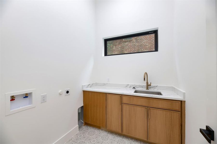 Washroom featuring hookup for a gas dryer, cabinet space, light tile patterned floors, and washer hookup Washroom featuring hookup for a gas dryer, cabinet space, light tile patterned floors, and washer hookup