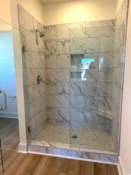 Full bathroom featuring wood finished floors and a shower stall
