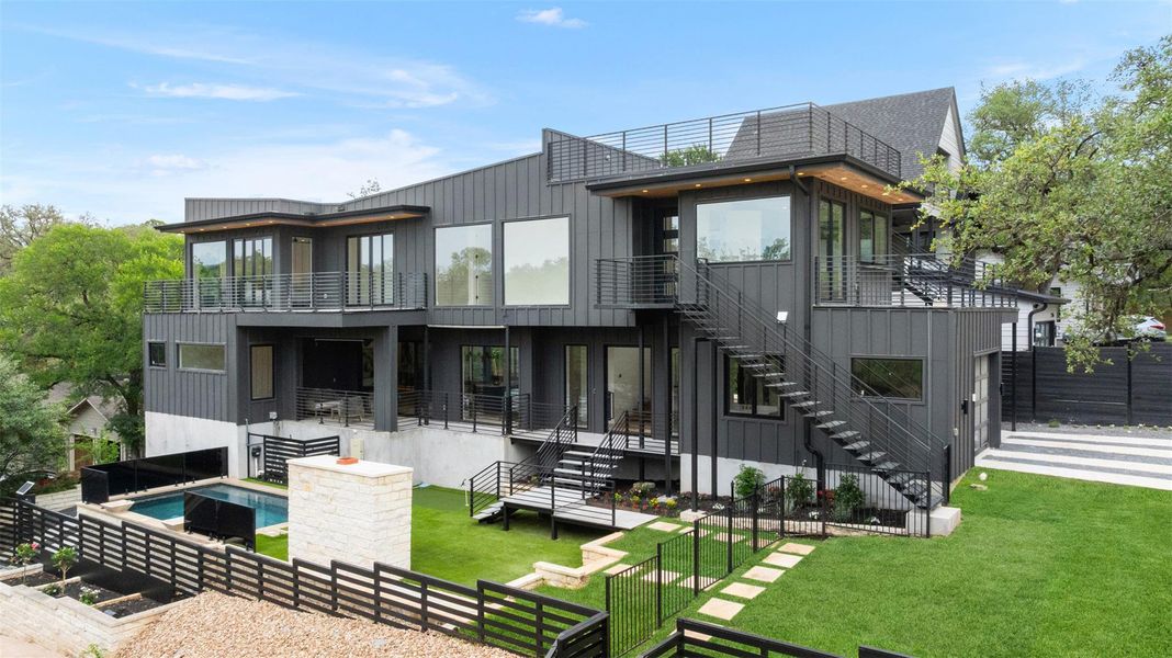 This property features a contemporary architectural style with dark panel siding and extensive window placements