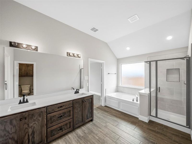 Bathroom with a shower stall, a bath, a sink, and visible vents Bathroom with a shower stall, a bath, a sink, and visible vents