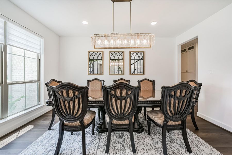 An elegant formal dining room featuring a custom-designed chandelier and refined recessed lighting. An elegant formal dining room featuring a custom-designed chandelier and refined recessed lighting.