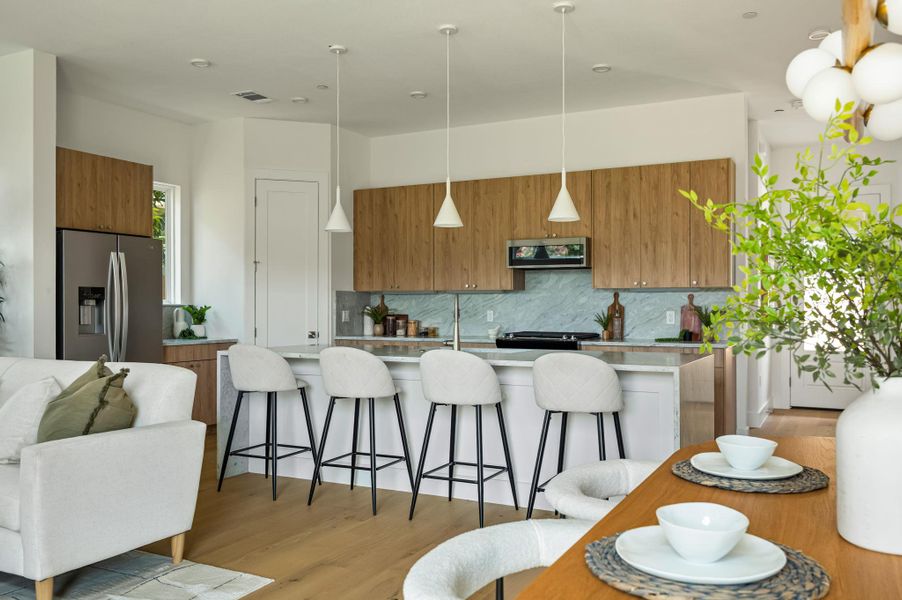 An inviting open-concept kitchen features a spacious island and sleek wooden cabinetry, perfect for entertaining. An inviting open-concept kitchen features a spacious island and sleek wooden cabinetry, perfect for entertaining.