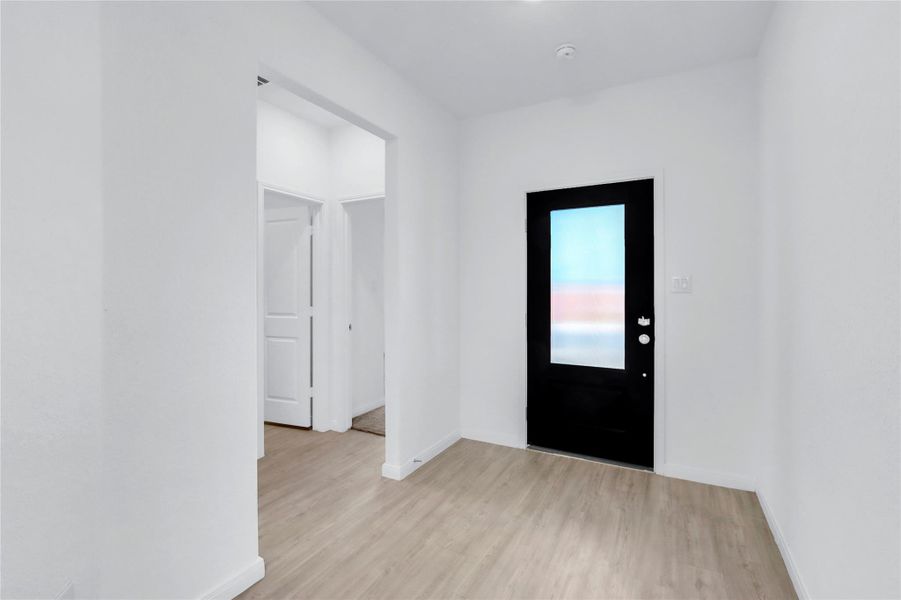 Foyer featuring light wood finished floors and baseboards