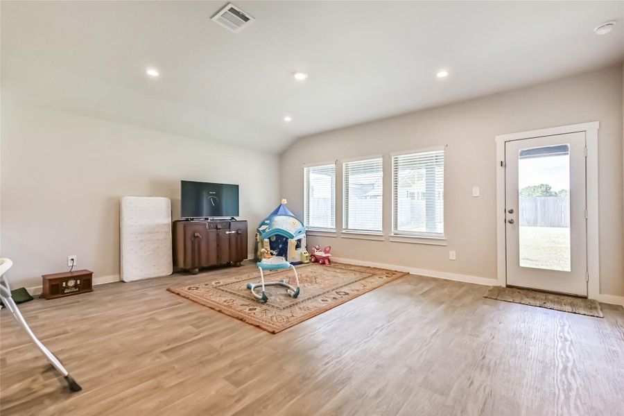 Spacious open-concept living room with neutral tones, natural light, and seamless flow to kitchen and dining.