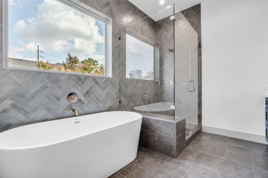 A closer view of the primary bathroom highlights the separate shower and soaking tub, with a glass window allowing natural light to brighten the space.