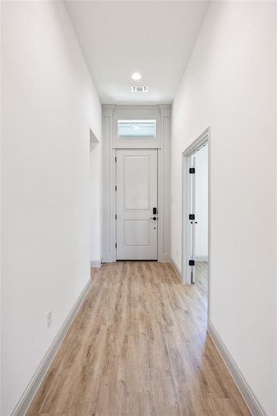 Doorway with wood finished floors and baseboards