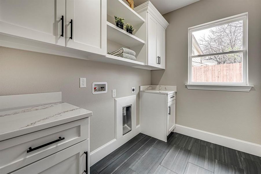 Clothes washing area featuring cabinets, hookup for a washing machine, and hookup for an electric dryer