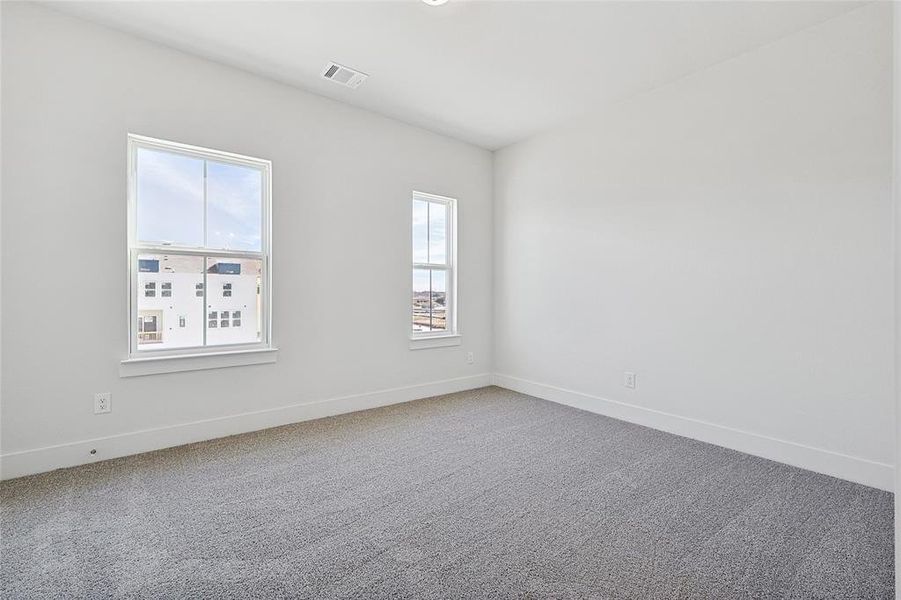Spare room with carpet and baseboards