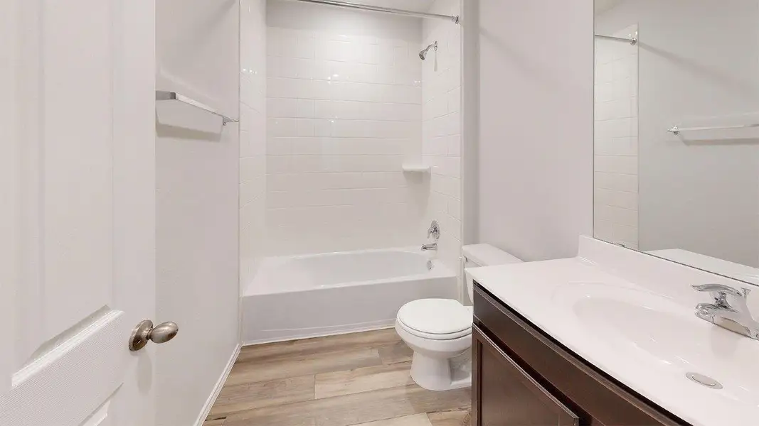 Full bath featuring vanity, light wood-type flooring, and shower / bathtub combination Full bath featuring vanity, light wood-type flooring, and shower / bathtub combination