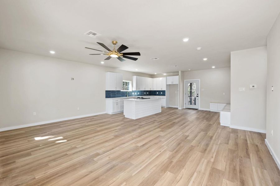 Unfurnished living room featuring recessed lighting, plenty of natural light, light wood-style flooring, and a ceiling fan Unfurnished living room featuring recessed lighting, plenty of natural light, light wood-style flooring, and a ceiling fan
