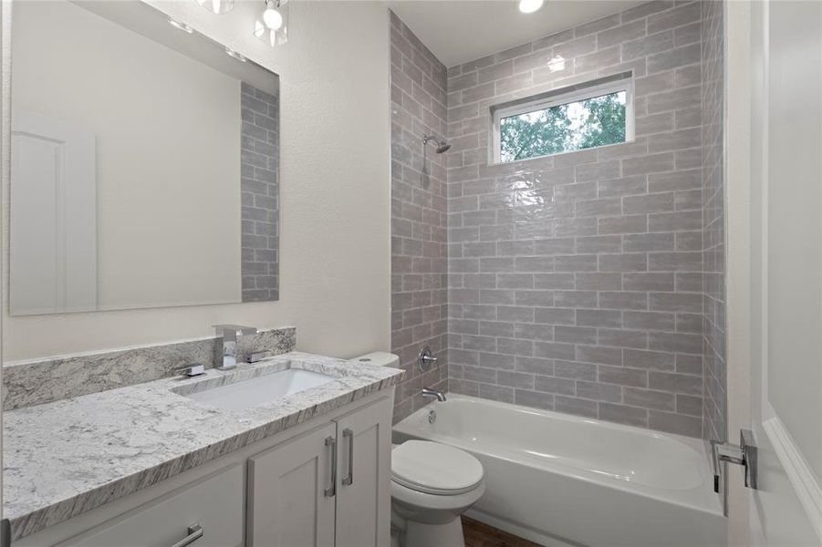 Bathroom featuring a white vanity with a granite-style countertop, undermount sink, and chrome fixtures Bathroom featuring a white vanity with a granite-style countertop, undermount sink, and chrome fixtures