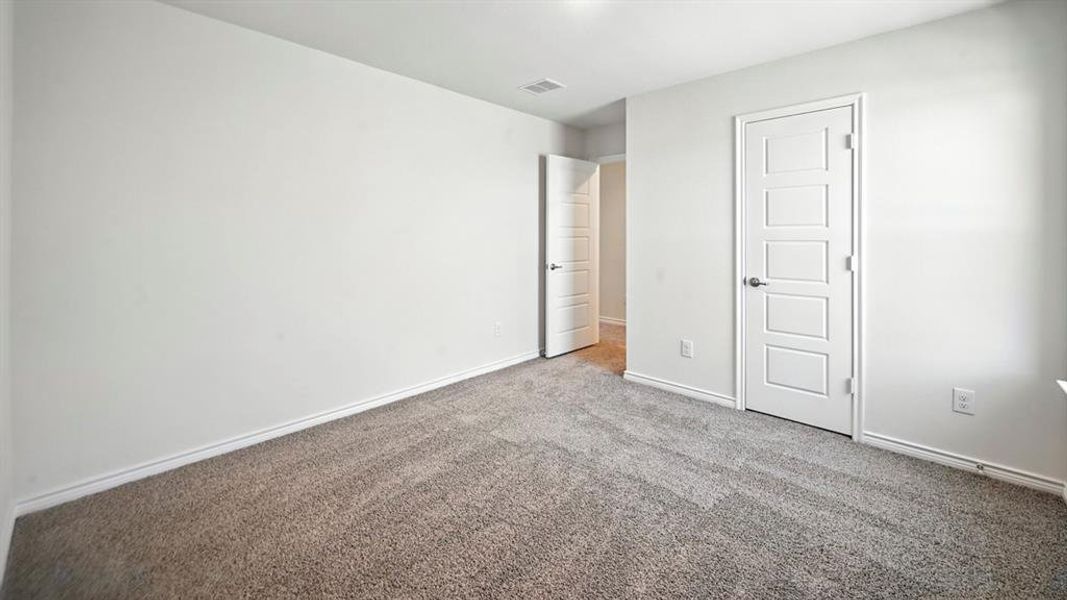 Unfurnished bedroom with carpet flooring and baseboards