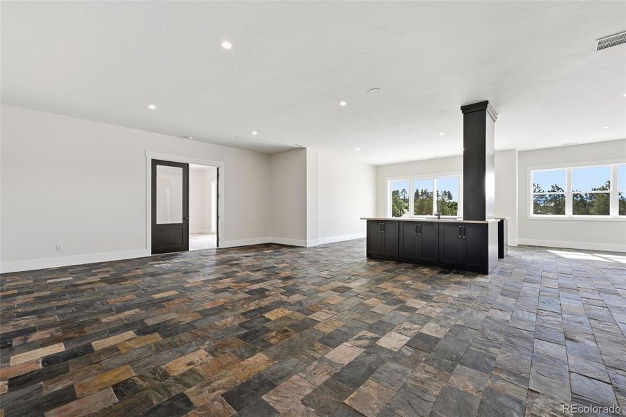 Lower-Level Family Room with wet bar, entrance to 2nd bedroom (left) and sliding doors (over wet bar) in background. Lower-Level Family Room with wet bar, entrance to 2nd bedroom (left) and sliding doors (over wet bar) in background.