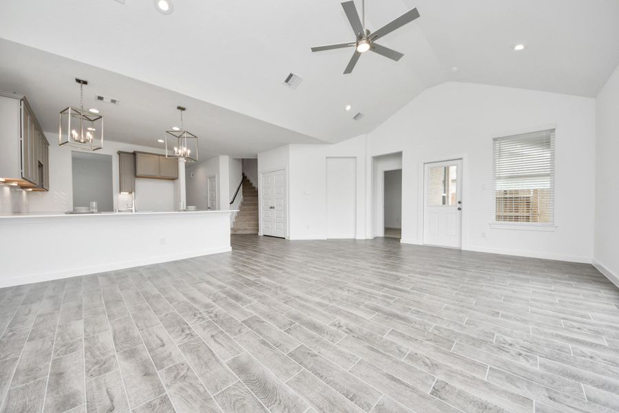 Gather the family and guests together in your lovely living room! Featuring soaring high ceilings, recessed lighting, ceiling fan, custom paint, gorgeous floors, and large windows that provide plenty of natural lighting throughout the day. Sample photo of completed home with similar floor plan. Actual colors and selections may vary.