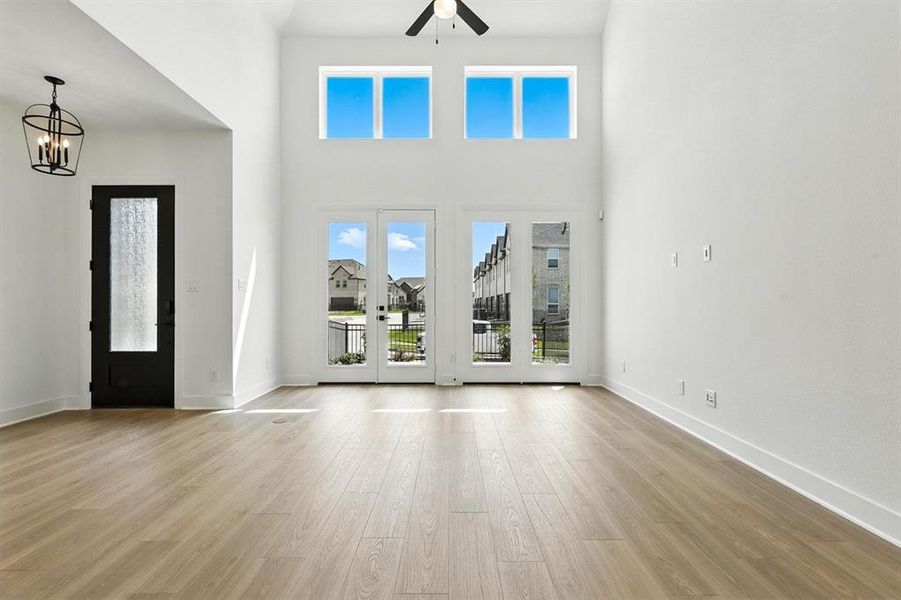 Entrance foyer with a high ceiling, light wood-style floors, and ceiling fan Entrance foyer with a high ceiling, light wood-style floors, and ceiling fan