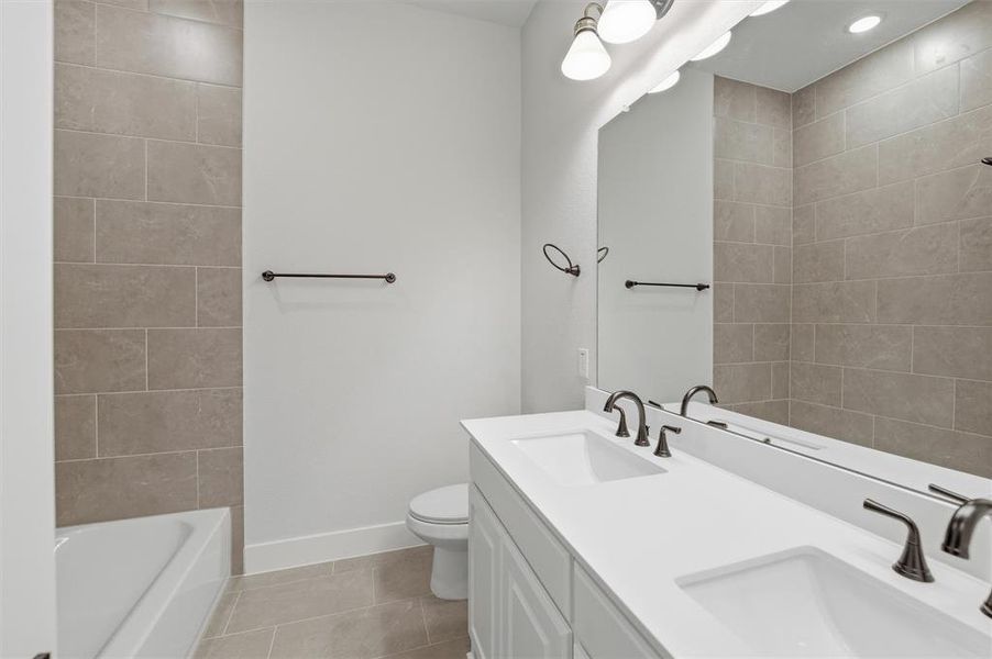 The bathroom features a double vanity with two rectangular sinks, dark bronze fixtures, and a large mirror