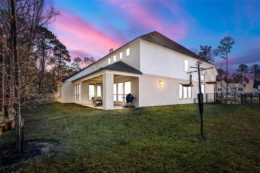 This spacious backyard with a covered patio is perfect for outdoor dining and relaxation.