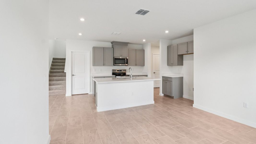 Kitchen and Living Room in the Monterey End Townhome by DRB Homes - Cyrene at Harmony in St Cloud FL