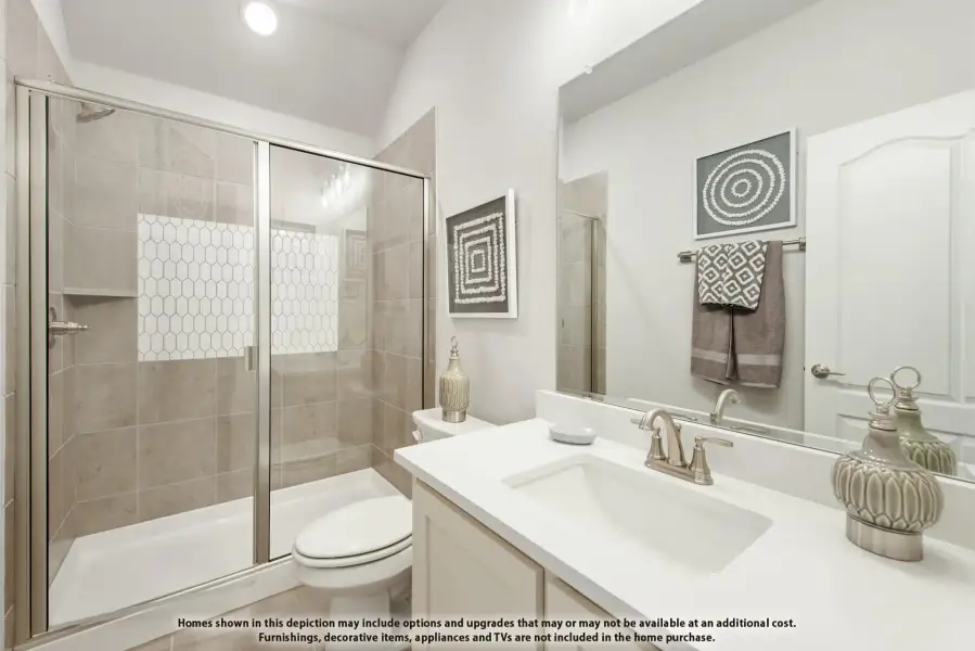 Bathroom with white countertop vanity, glass-enclosed tiled shower, and large mirror