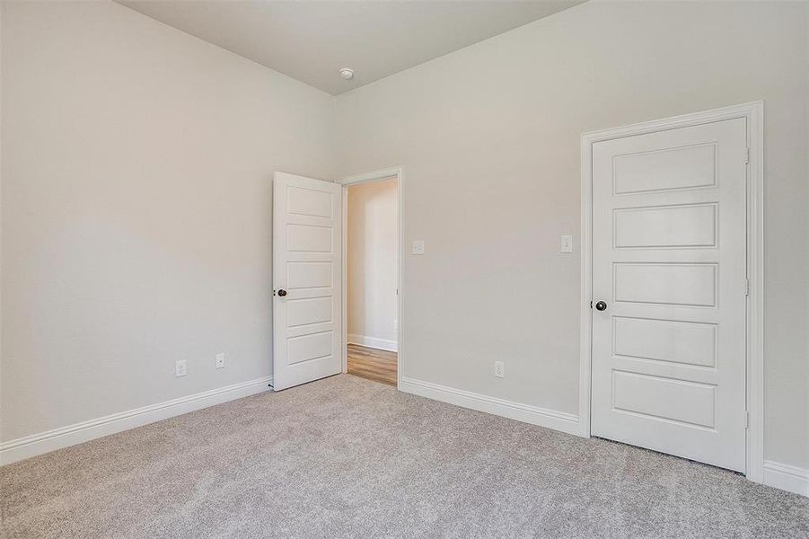 Unfurnished bedroom with light colored carpet