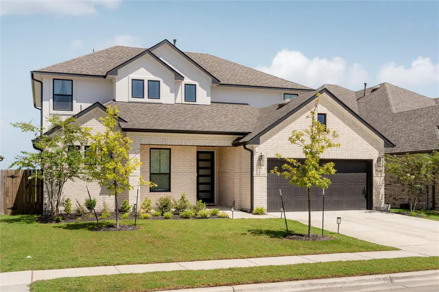 A striking modern facade with light brick and dark trim offers exceptional curb appeal. A striking modern facade with light brick and dark trim offers exceptional curb appeal.