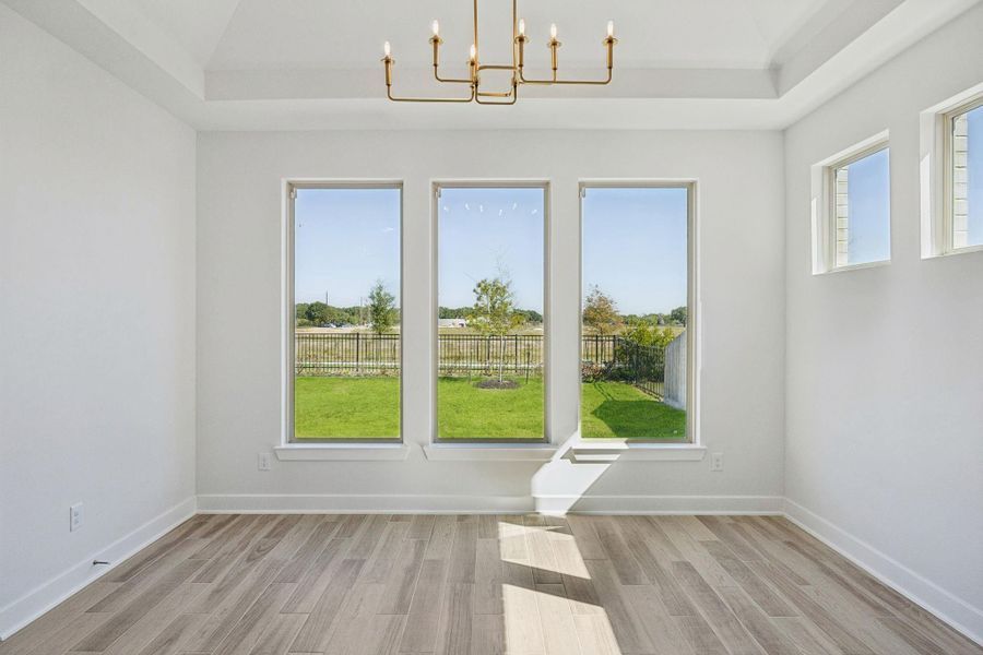 The dining room, located next to the kitchen, features large windows overlooking the backyard and is accented by an elegant chandelier. The dining room, located next to the kitchen, features large windows overlooking the backyard and is accented by an elegant chandelier.