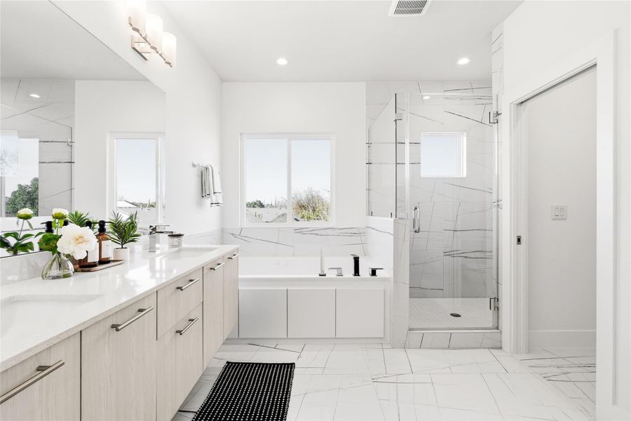 Primary ensuite with abundant storage, full tile surround, and a bright, airy layout.