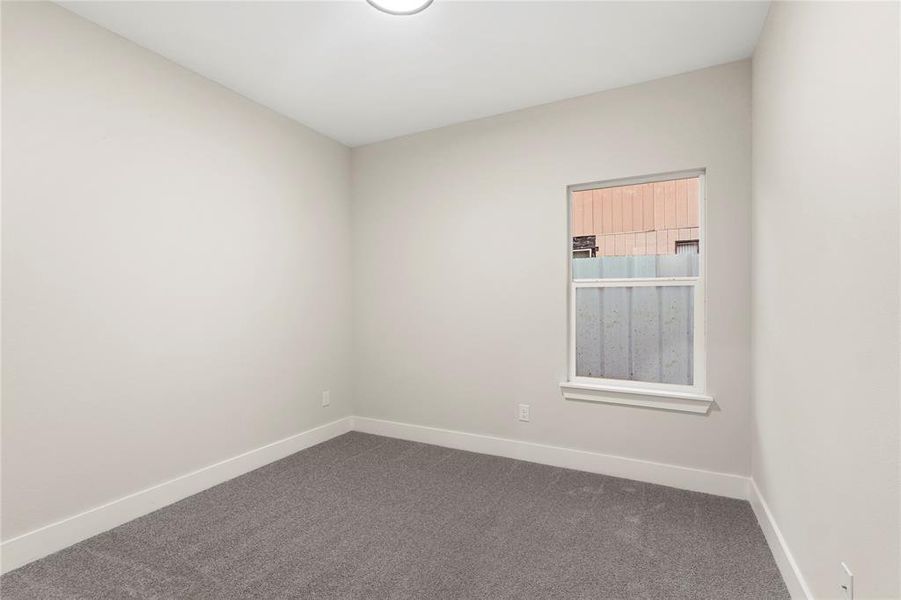 Unfurnished room with dark colored carpet and baseboards Unfurnished room with dark colored carpet and baseboards