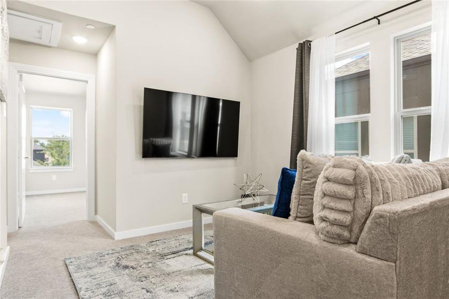 Carpeted living room with vaulted ceiling