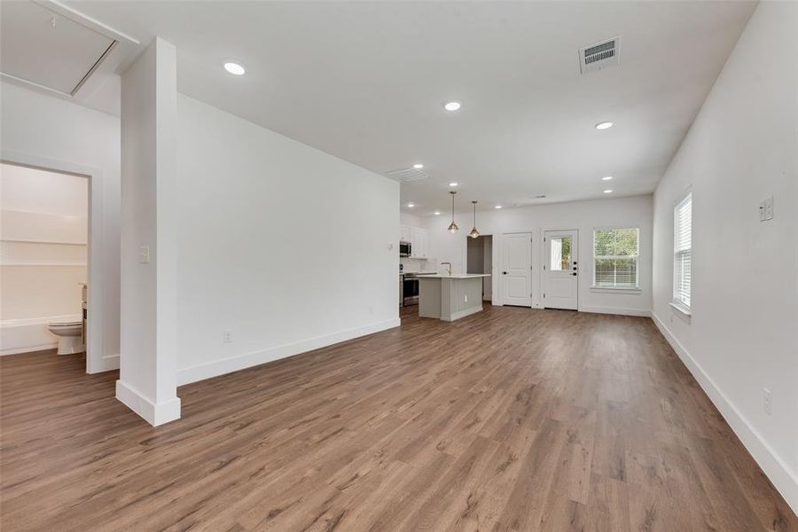 Unfurnished living room featuring recessed lighting and dark wood-type flooring Unfurnished living room featuring recessed lighting and dark wood-type flooring
