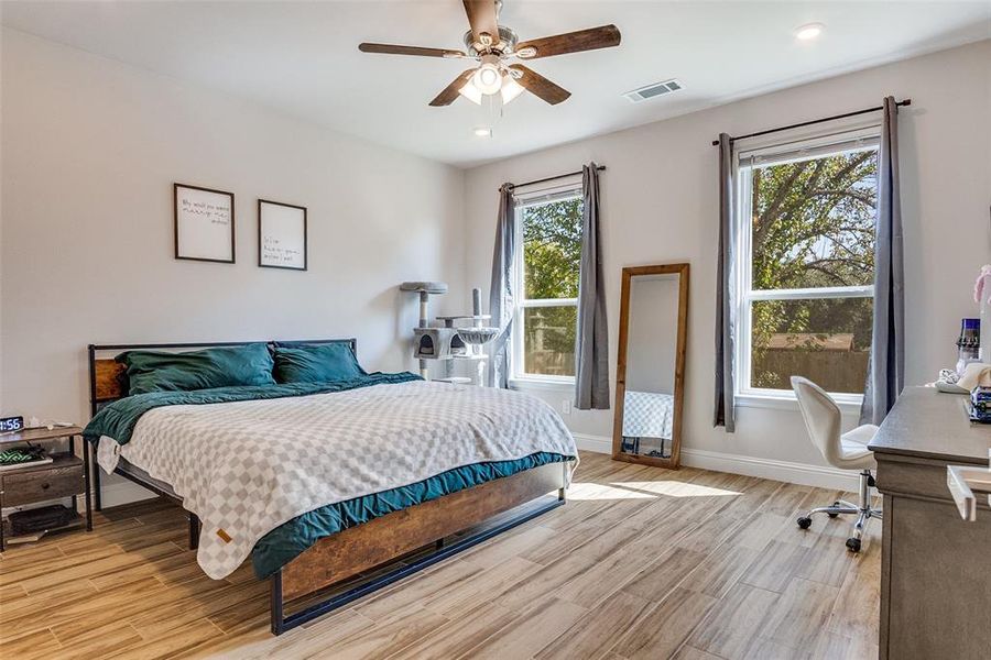 Bedroom featuring light wood-style flooring, a ceiling fan, and an office area