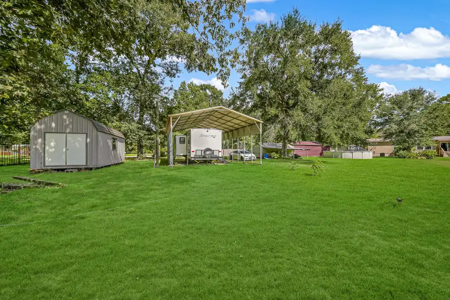 24' x 35' RV carport with 10' legs. The tan storage building is excluded from the sale.