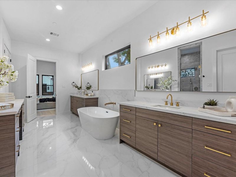 Additional view of the primary suite bath, featuring a walk-in shower with dual shower heads.